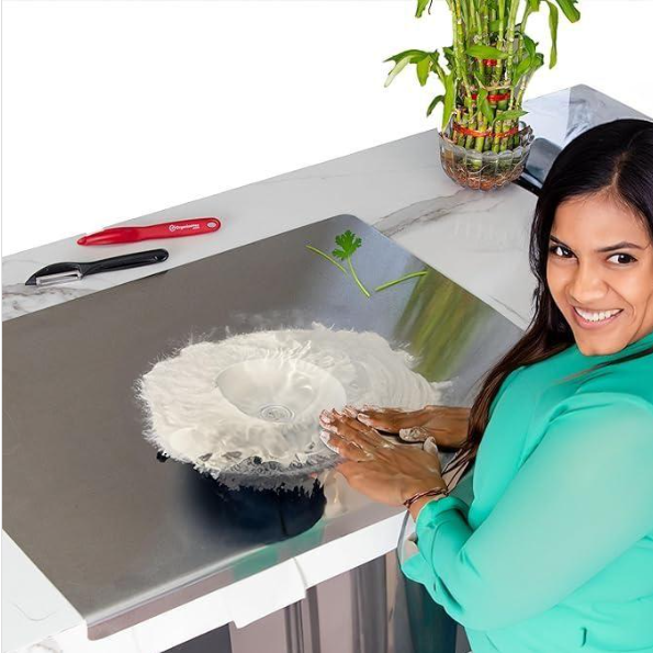 Woman using a cleaning tool on a surface with a plant and tools in the background