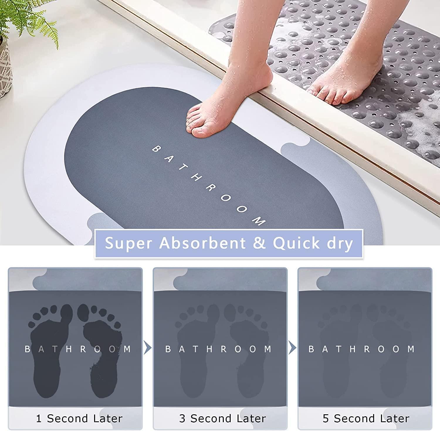 Gray bath mat with 'Bathroom' text, showing absorbent properties with water droplets.