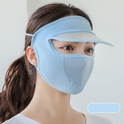 Woman wearing a light blue face mask with visor on a plain background