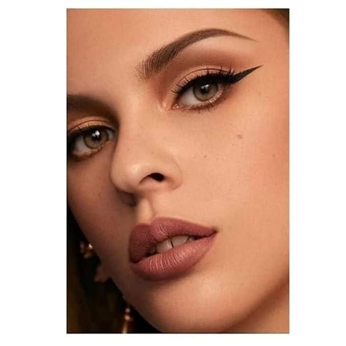 Close-up of a woman's face with makeup, including eyeliner and lipstick.