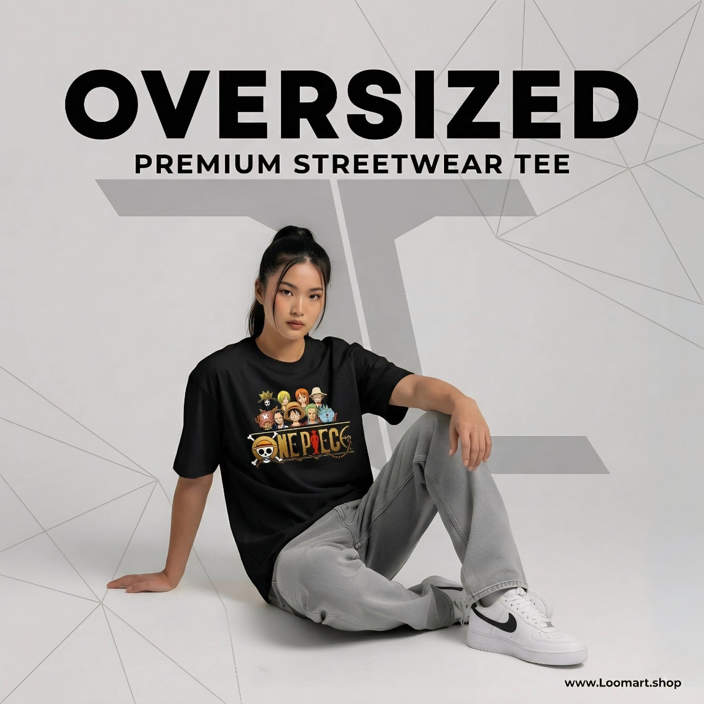 Person wearing a black oversized streetwear tee with graphics, sitting on a white floor.