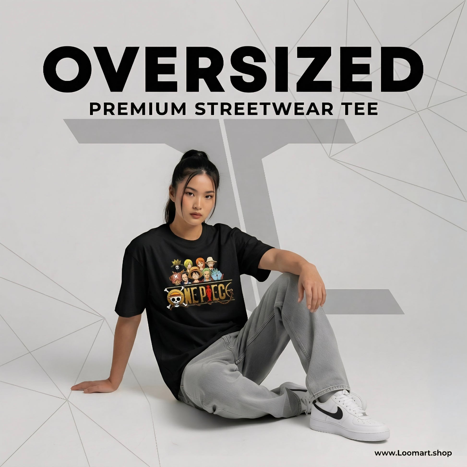 Person wearing a black oversized streetwear tee with graphics, sitting on a white floor.