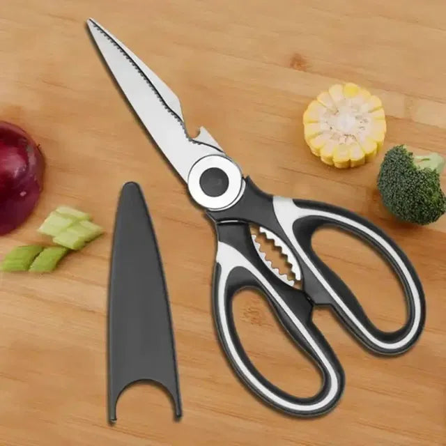 Kitchen shears on a wooden surface with vegetables
