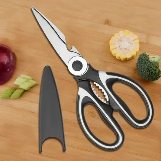 Kitchen shears on a wooden surface with vegetables