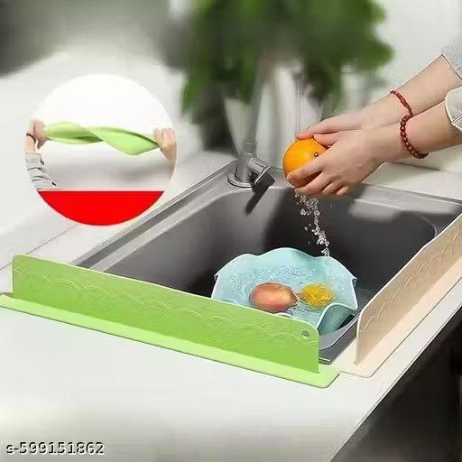 Person washing fruits and vegetables in a sink with a green kitchen sink extension.