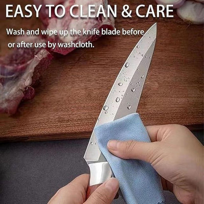 Person cleaning a knife blade with a cloth on a wooden cutting board.
