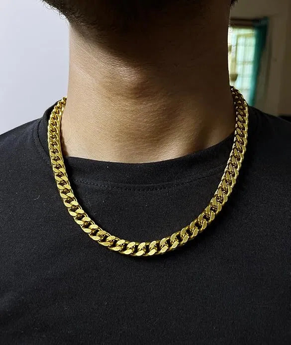 Gold chain necklace worn by a person on a black shirt